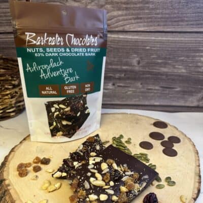 Loose and packaged chocolate bark on wood slab