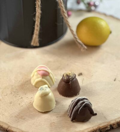 four chocolates on wood with lemon in background
