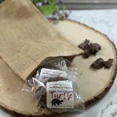 packaged dark chocolate caramel turtles coming out of burlap sack