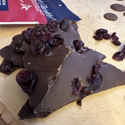 Loose Dark Chocolate with Cranberries on wood slab