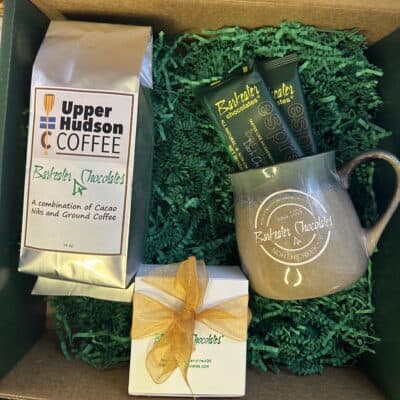Open gift box with coffee, mug, chocolate bars and small box of chocolates