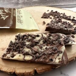 loose milk and white chocolate with nibs on wood slab