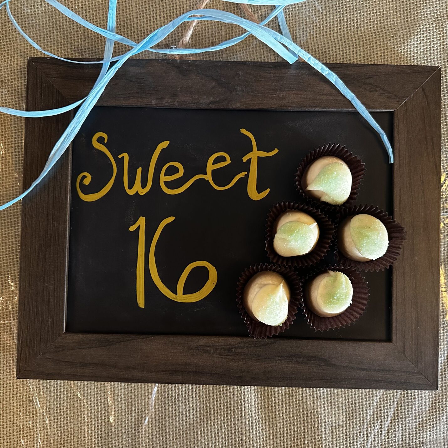 chalkboard that says sweet 16 with white chocolate truffles next to the words