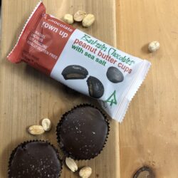 loose and packaged peanut butter cups with peanuts on a table