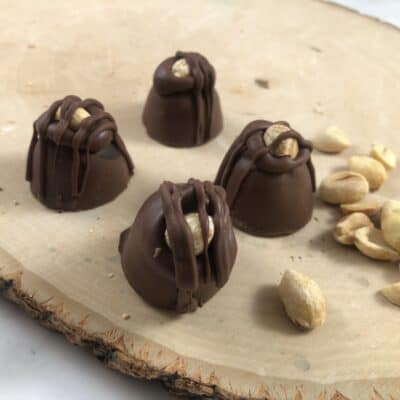 loose peanut butter truffles and peanuts on a table