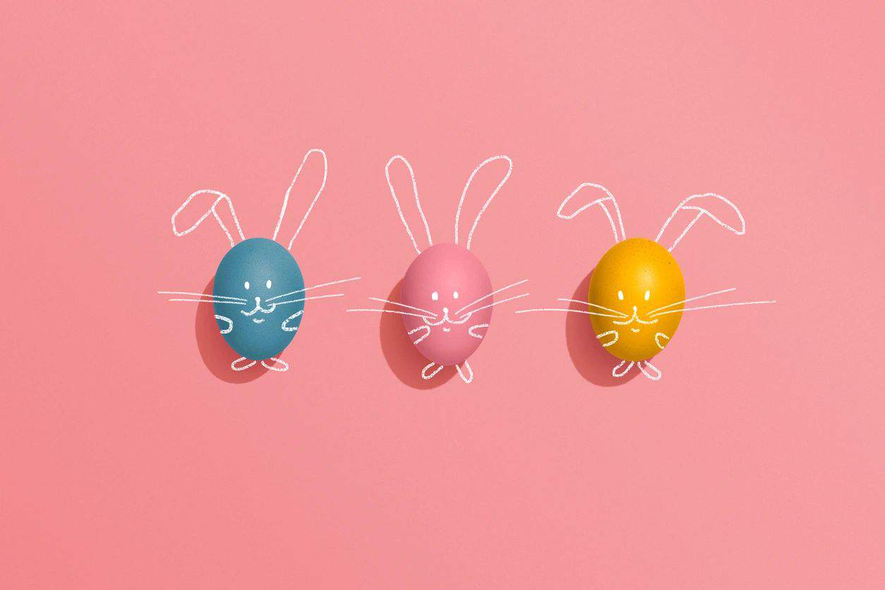 Easter eggs on pink background with bunny ears drawn on
